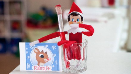 Elf sitting in a cup with a paintbrush