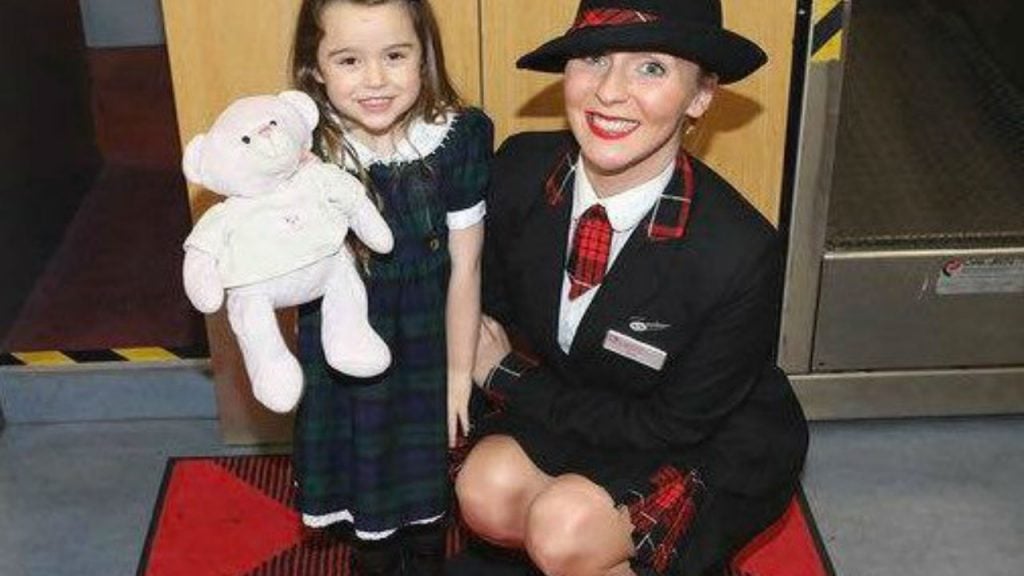Summer with her teddy and Loganair staff