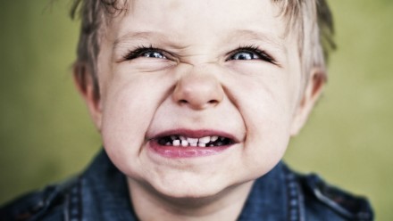 A little boy clenching his teeth.