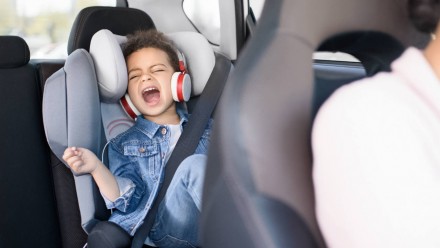 A little boy singing in the backseat of a car