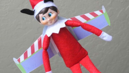 An Elf on the Shelf wearing Buzz Lightyear wings and Mickey Mouse ears