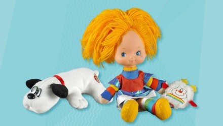 blue background with '80s toys including Rainbow Brite doll and a Pound Puppy
