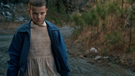 Stranger Things character, Eleven, stares fiercely at something off-camera.