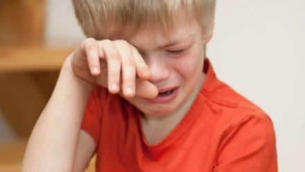 A young boy crying.