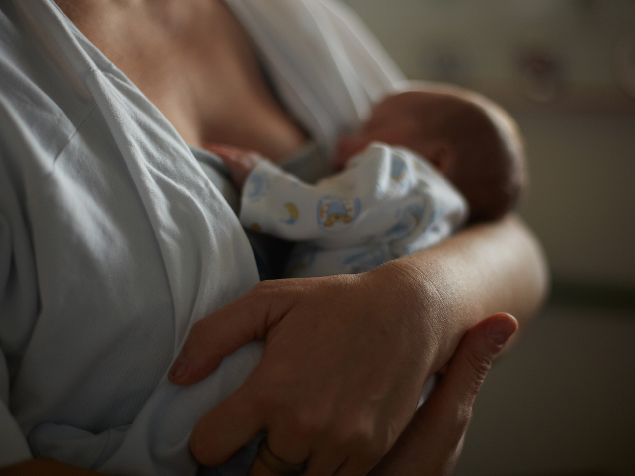 Mãe segurando o seu bebé prematuro nos seus braços