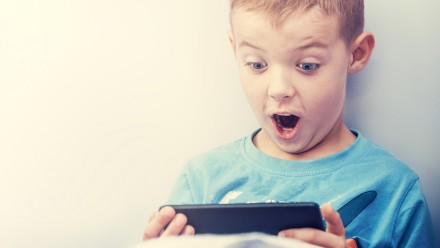 Excited boy playing with a smartphone