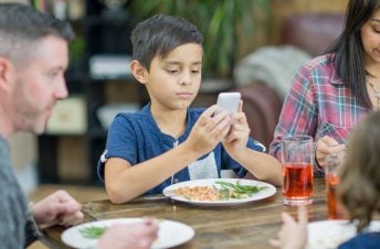 Little boy looking at smartphone at the table