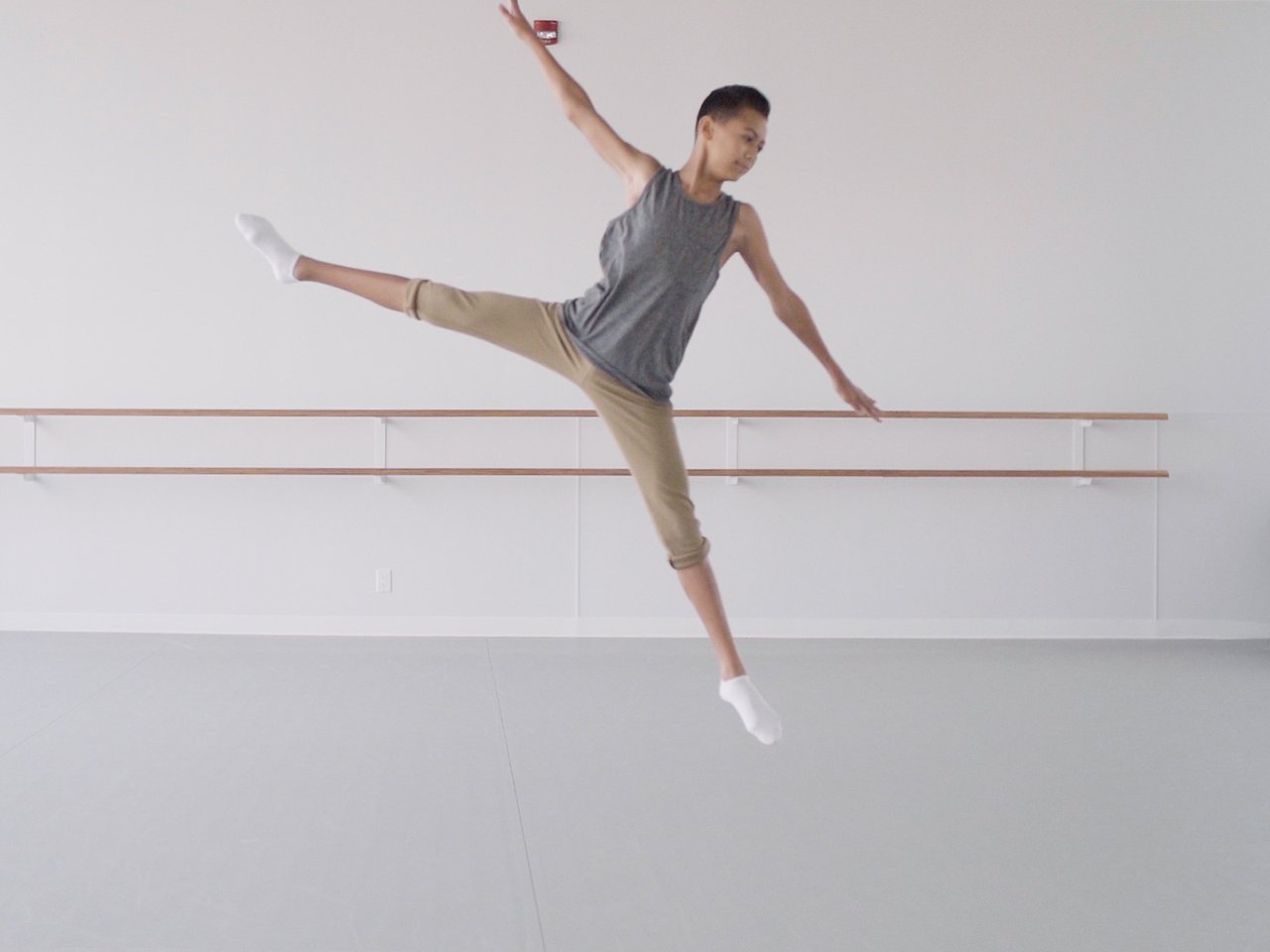 Young boy named Kai in a mid-air dance position