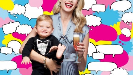 Mother dressed up holding a baby and a glass of champagne