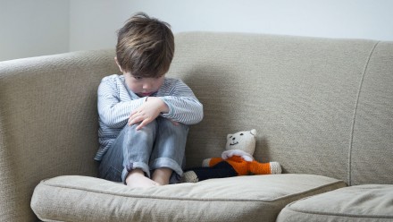 Little boy looking sad on the couch