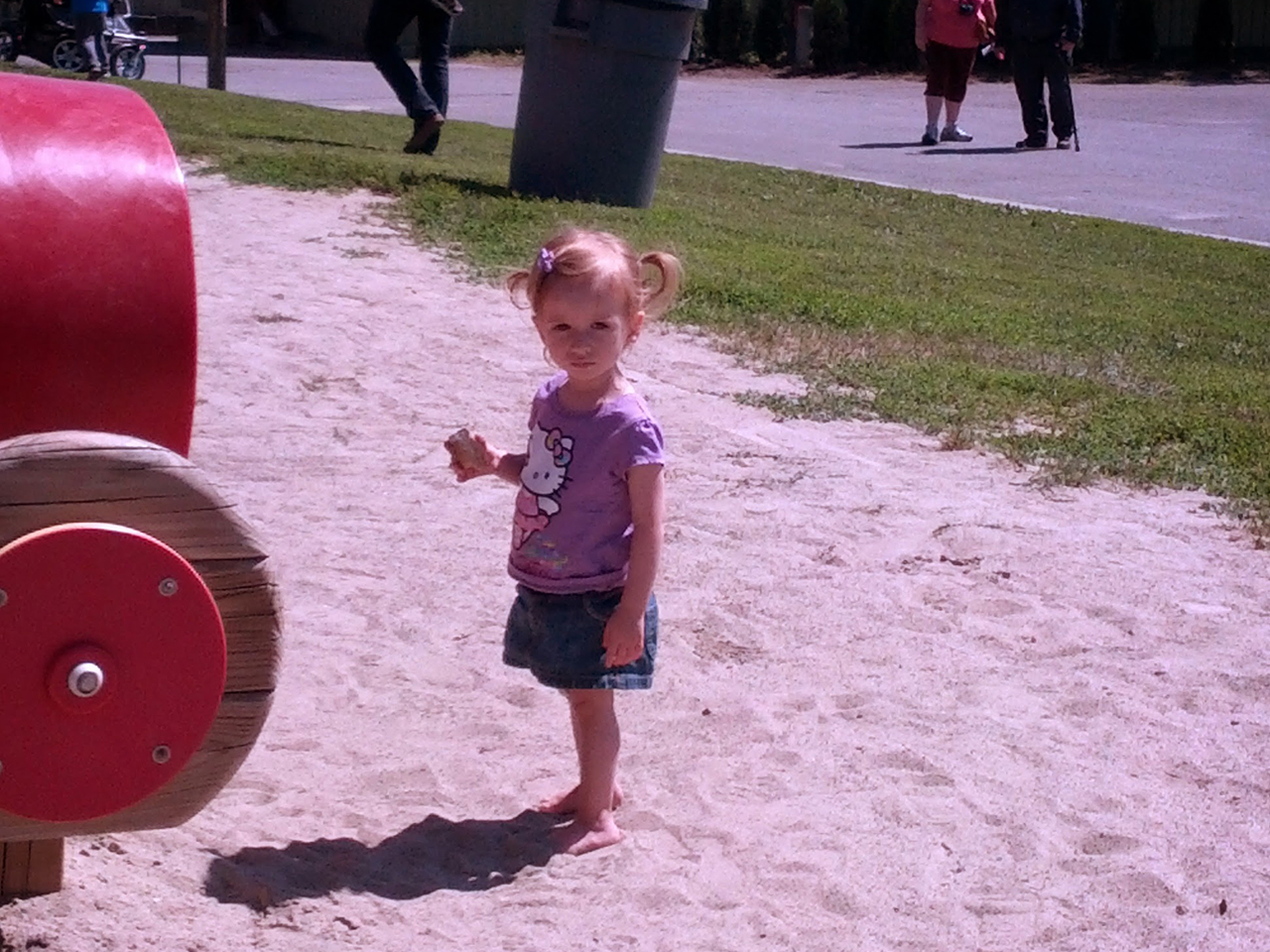 Little girl at the park standing in the sand