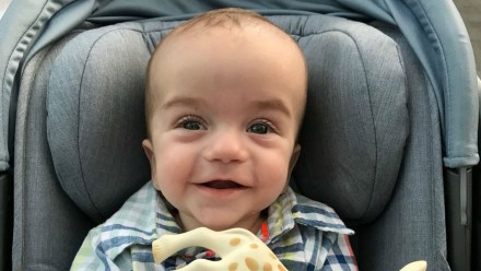 Photo of Jimmy Kimmel's infant son, holding a plastic toy giraffe.