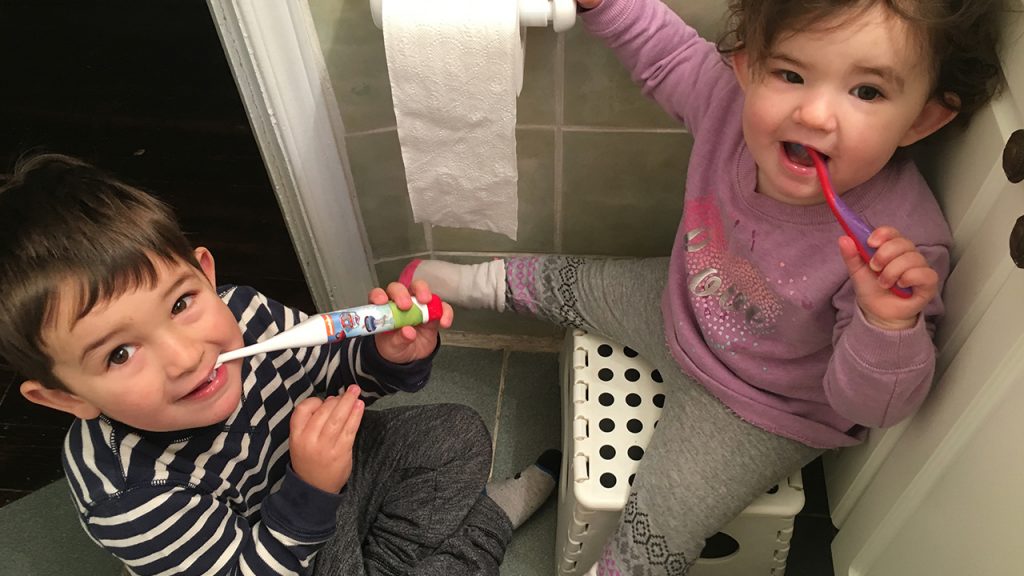 Two kids brushing their teeth