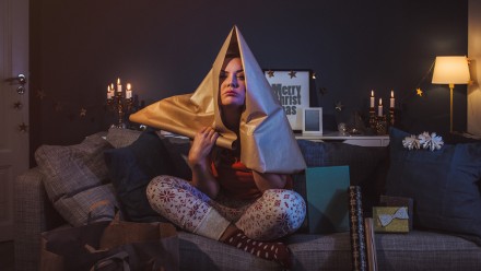 woman sitting on the couch with wrapping paper on her head