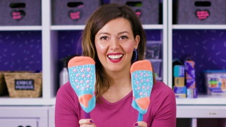 A woman holding up colourful socks