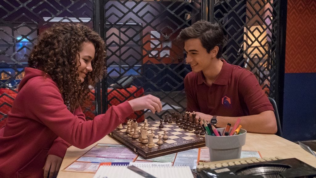 A boy and girl from Greenhouse Academy play a game of chess
