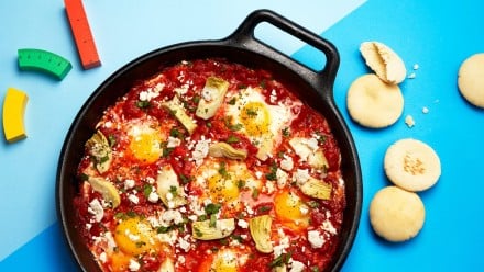 Skilled with tomato, artichoke, fried eggs and crumbled feta cheese