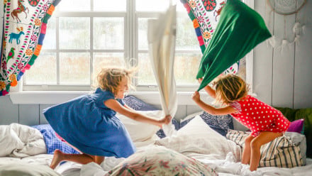Photo of two little girls having a pillow fight
