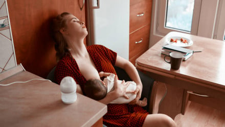 Ill mother contemplating taking cold medicine while breastfeeding