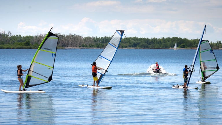 A group of windsurfers on the water