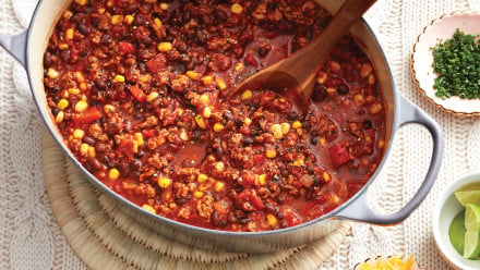 Dutch oven of turkey chili with chunks of tomato and corn