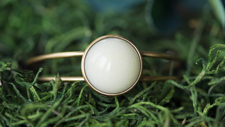 Bronze cuff bracelet with white opaque stone in the middle