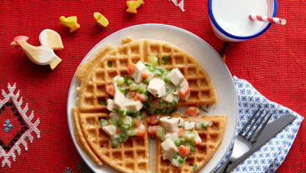 Plate with waffle that's topped with creamy chicken potpie filling