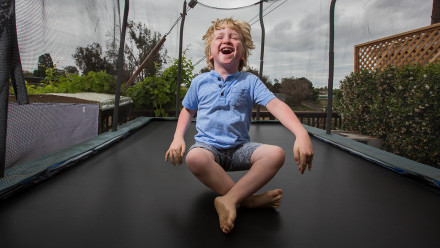 Young boy bouncing happily on a trampoline