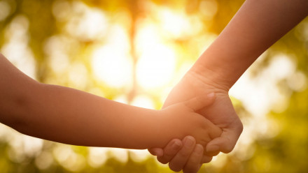 Photo of a child and a mother holding hands