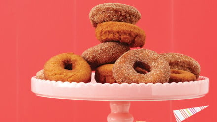 Pink platter with sugar-coated doughnut rings and doughnut holes