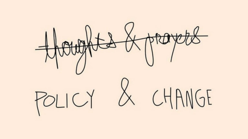 A note card that says policy and change and has the words thoughts and prayers crossed out