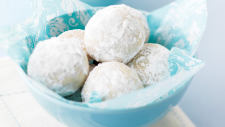 Blue bowl with powdered sugar-dusted coconut balls