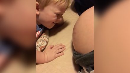 Little boy looking at his mom's pregnant belly
