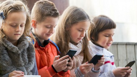 A group of kids on smartphones and iPad