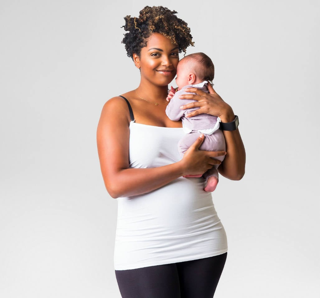 A woman holding a baby wearing a white nursing bra tank top