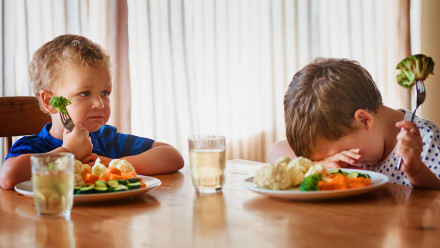 Two kids resist eating vegetables