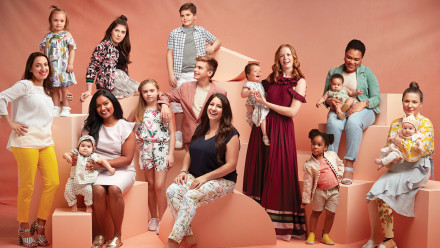 Group shot of six moms and their children sitting on various boxes