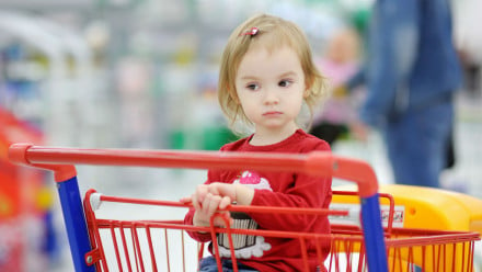Girl sitting in a grocery cart