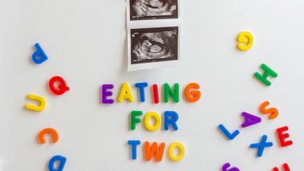 Fridge magnets spelling out "Eating for Two" underneath an ultrasound picture