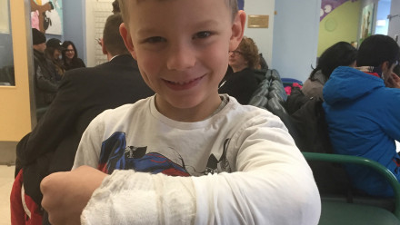 Boy smiling with a cast on his arm