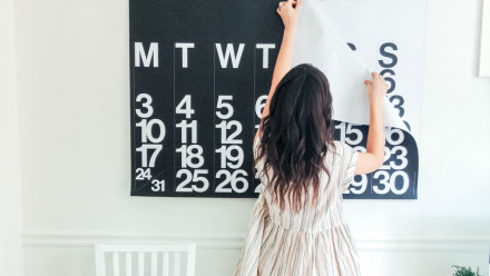 A woman changing her wall calendar