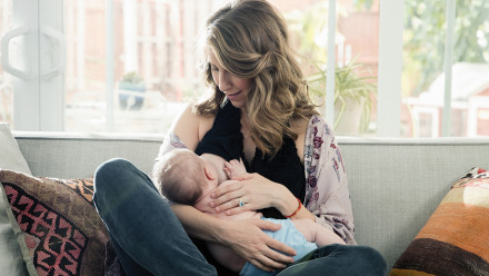 Photo of a woman breastfeeding while wearing the new Maternity Ta-Ta Towel