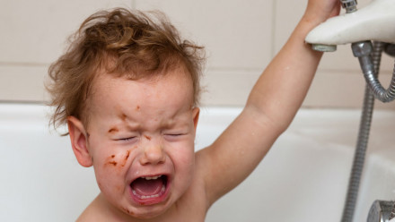 Kid upset in bath tub.