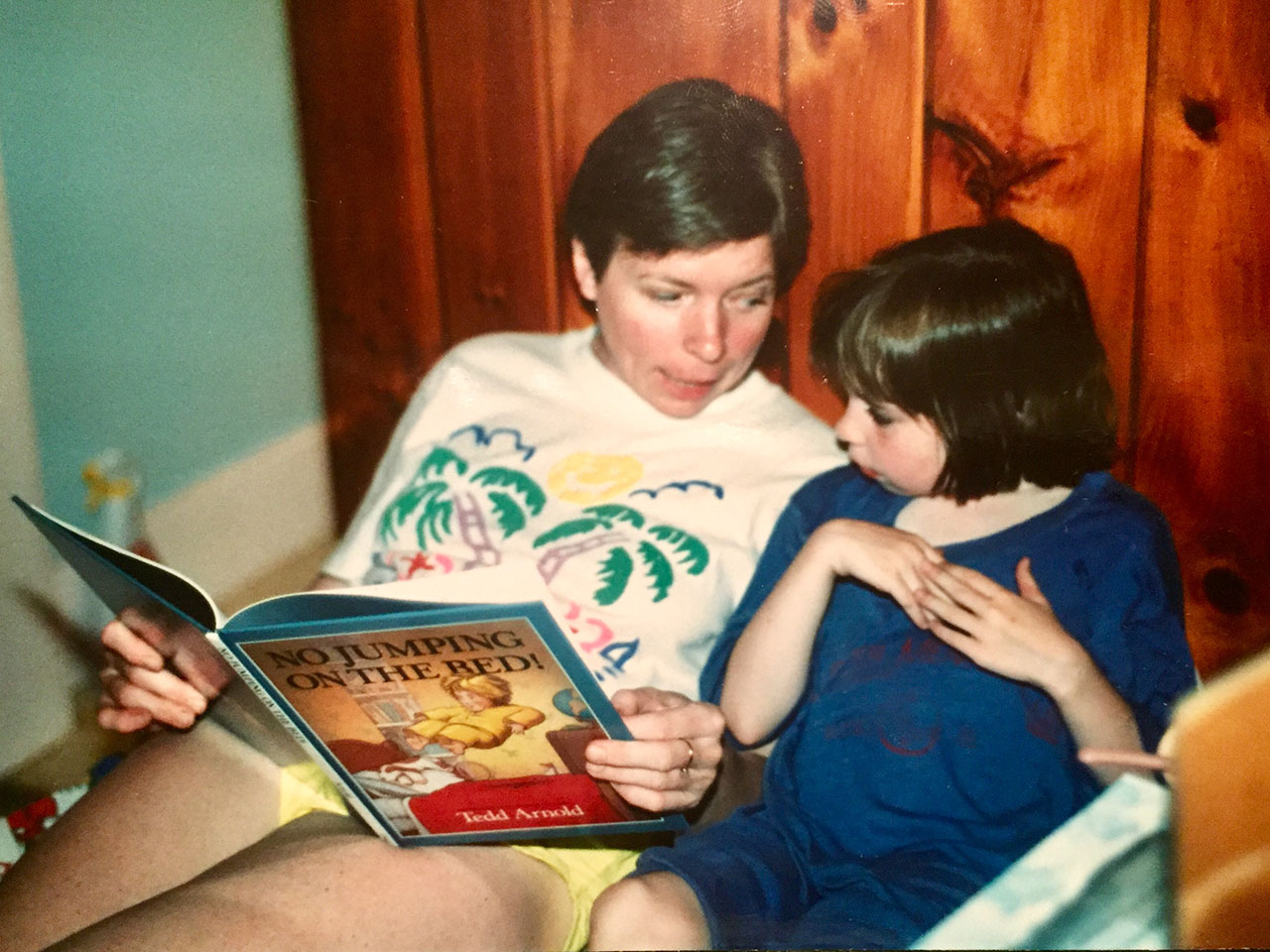 Carol Weis reading a book to her daughter in bed