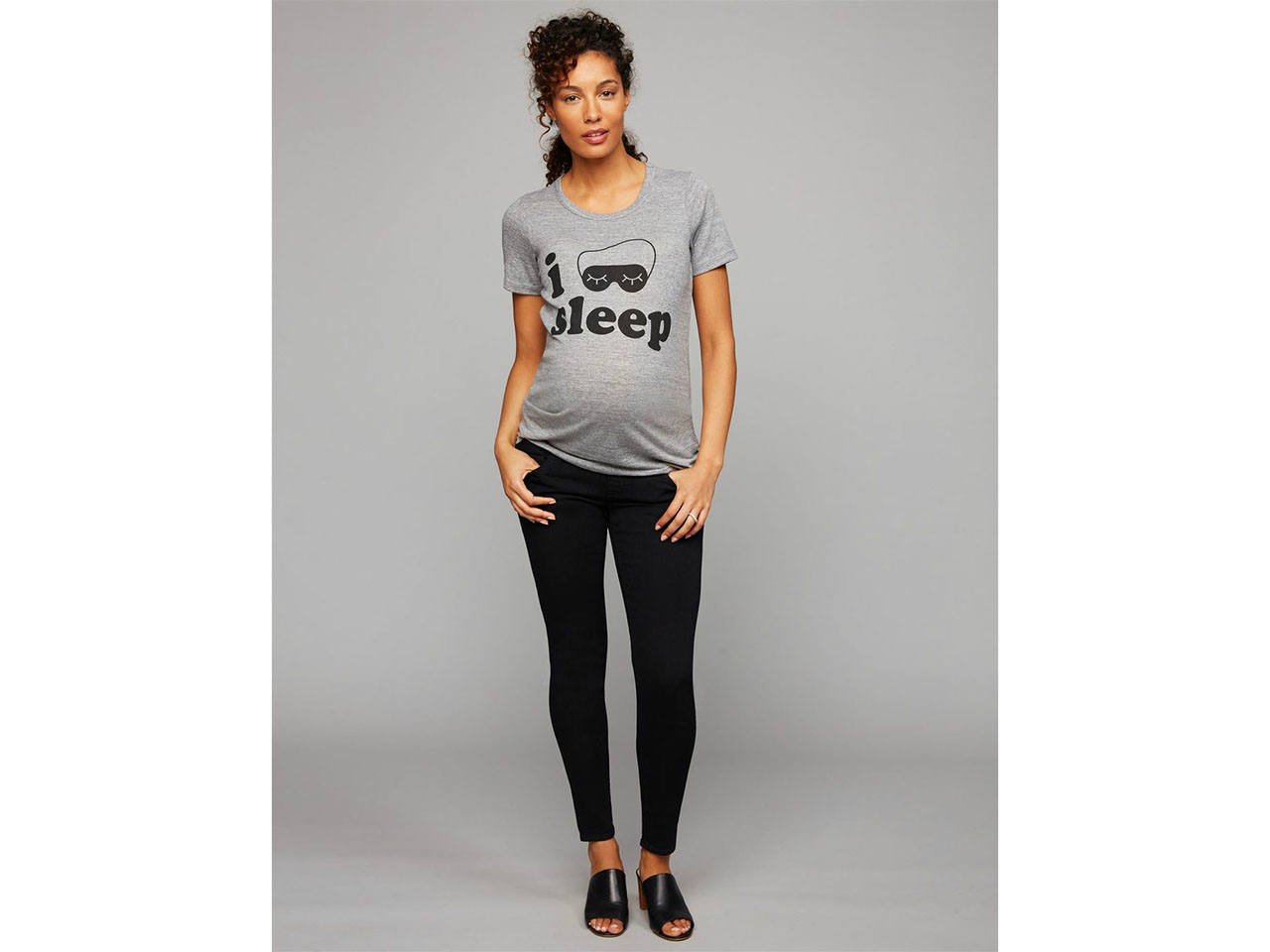 A pregnant woman wearing a grey maternity t-shirt that says I sleep