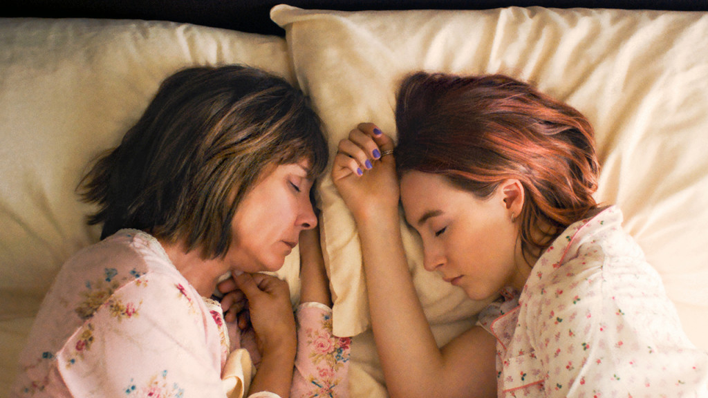 Promo image for Lady Bird showing a mom and daughter duo laying in bed