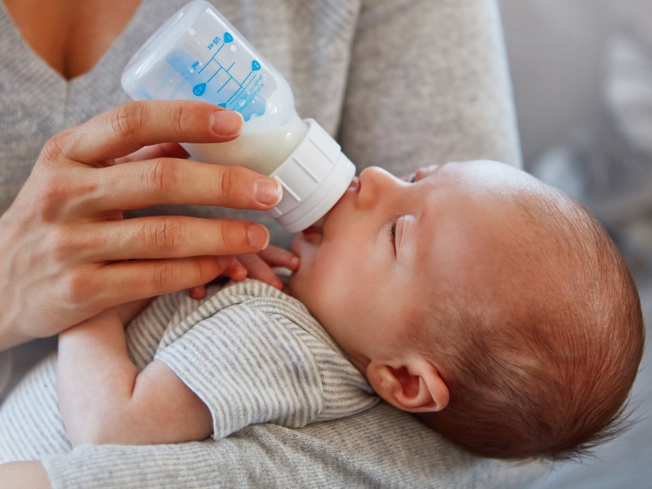 Closeup shot of a mother feeding her newborn baby from a bottle