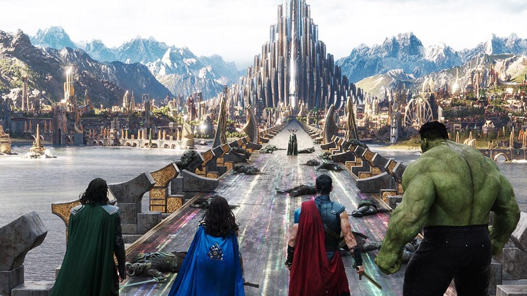 Promo image for Thor: Ragnarok showing Thor, Loki, Valkerie and the Hulk looking at Asgard
