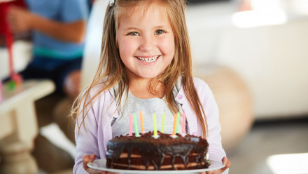 Little girl holding a birthday cake