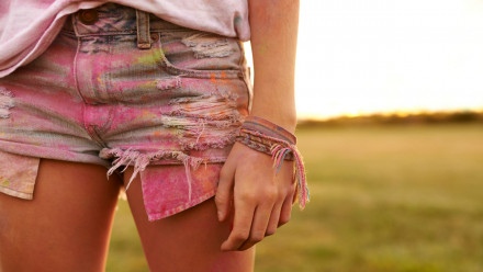 Lower body of a girl wearing shorts with color on it.